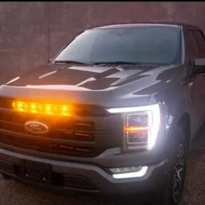 A black vehicle with its lights on